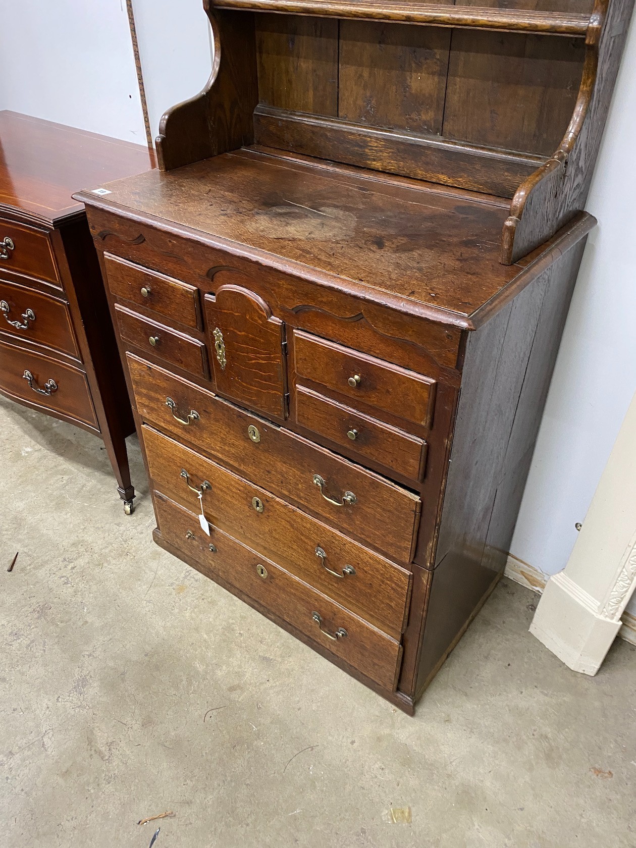 An 18th century oak chest of drawers with later associated oak shelves, width 79cm, depth 46cm, height 188cm